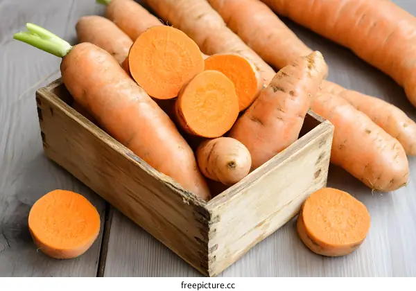 Fresh Carrots and Sweet Potatoes in a Wooden Crate