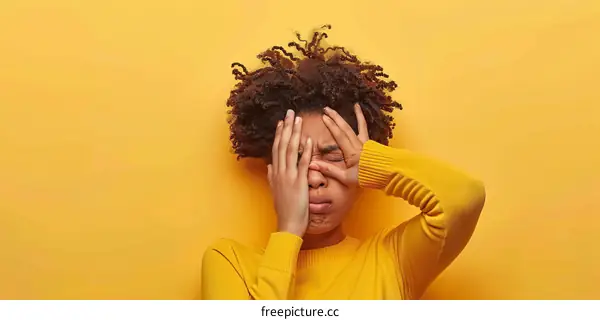 upset black woman covering her face with hands