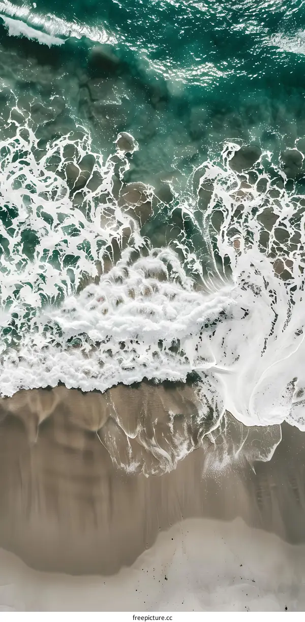 Aerial View of Ocean Waves Crashing on Sandy Beach