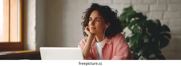 Woman Daydreaming with Headphones at Laptop