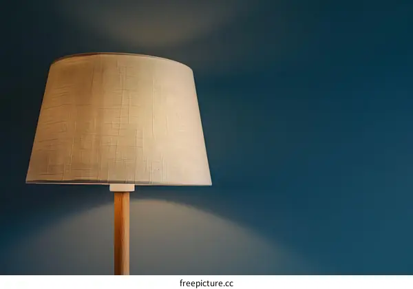 White Lamp Shade on Wooden Base Against a Teal Wall