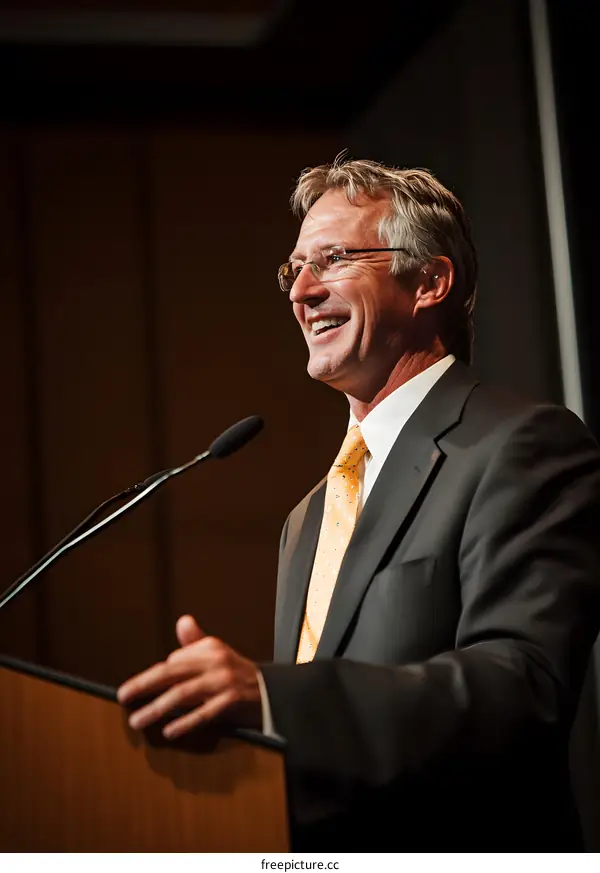 Man in Suit Speaking at Podium with Microphone