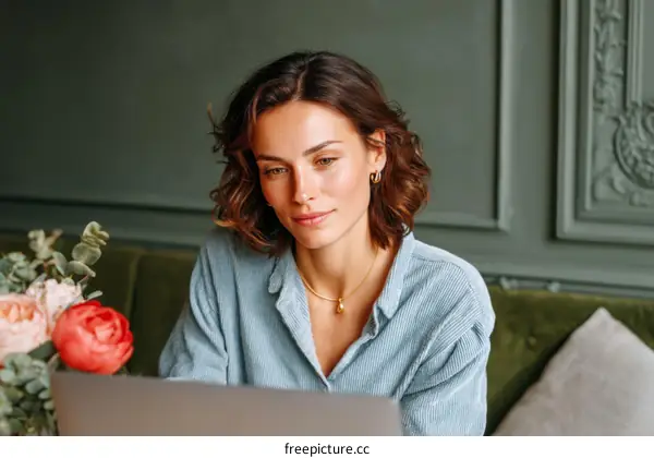 Woman Working on Laptop in Cafe Setting