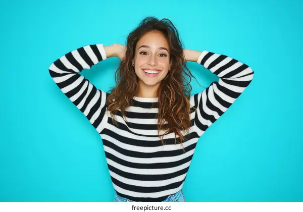 Smiling Woman in Striped Sweater against a Blue Background