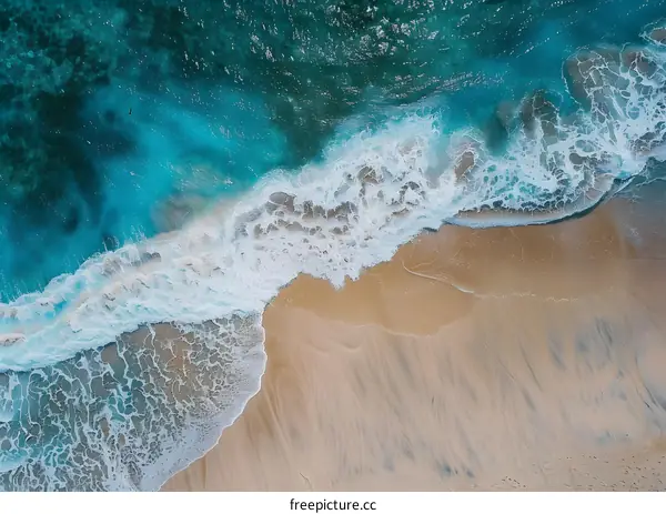 Aerial View of Ocean Waves Crashing on Sandy Beach