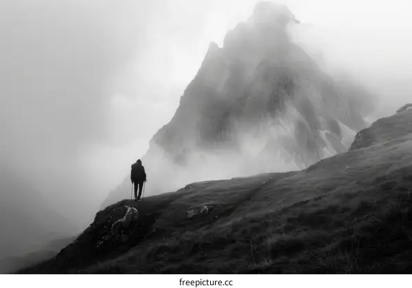 Man hiking alone in the mountains on a foggy day