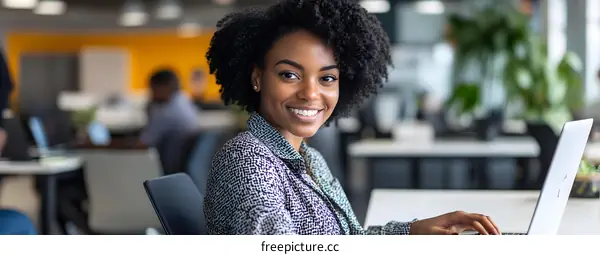 Smiling Black Businesswoman Working on Laptop in Modern Office