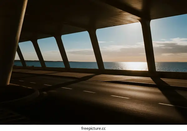 Sunset view from under a modern bridge over the sea