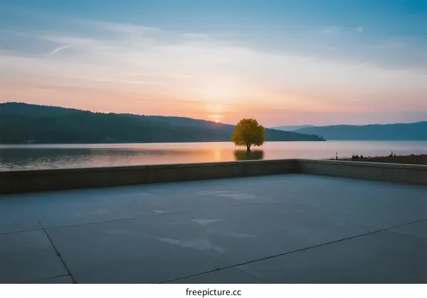 Serene sunset scene with a lone tree in the middle of a lake