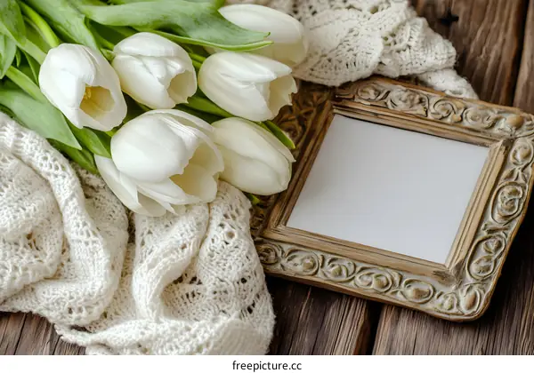 White Tulips with Ornate Frame and Knitted Scarf on Wooden Background