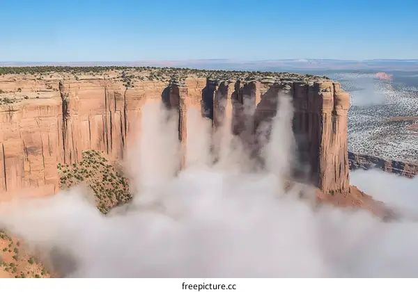 A Breathtaking View of a Canyon With Clouds Rising Around the Cliffs