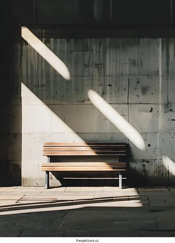 Wooden Bench Under Sunrays Against Concrete Wall