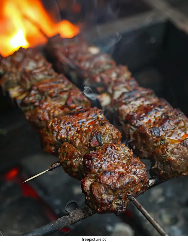 Beef skewers are grilled over an open flame.