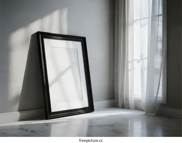 Empty picture frame standing near window with white curtains