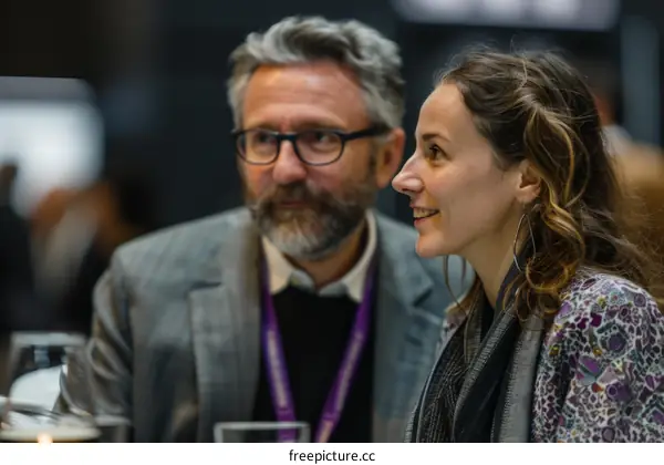 A man and a woman are sitting at a table and talking.