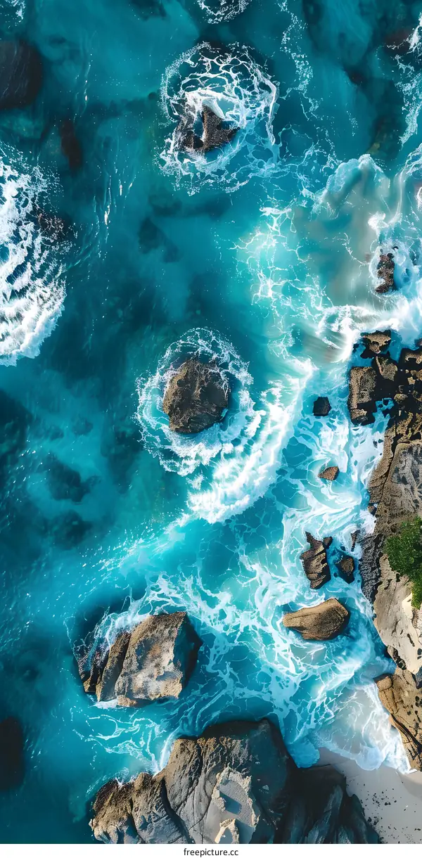 Aerial View of Turquoise Ocean Waves Crashing Against Rocks