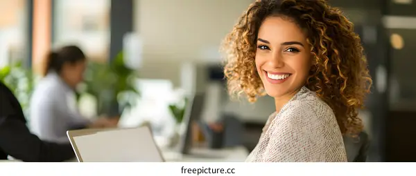 Smiling Business Woman Working on Laptop in Office