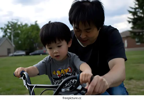Father Teaching Son How To Ride A Bike