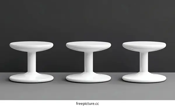 Three Modern White Round Stools in a Studio Setting