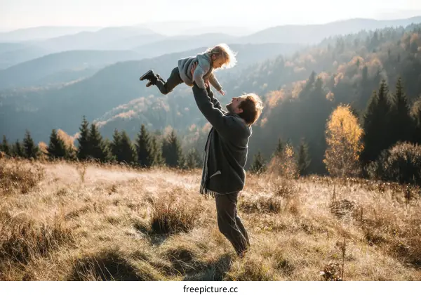 Father Lifting Child in Mountains