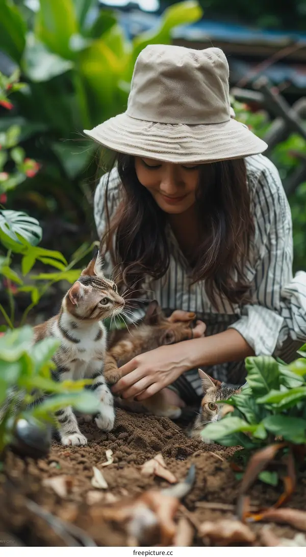 A young woman is gardening with two cats