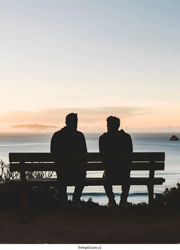 Two Men Sitting on a Bench at Sunset