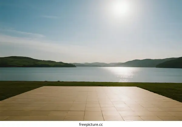 Sunlit Open Platform Overlooking Calm Lake and Rolling Hills