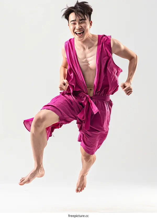 Ecstatic Asian man in pink traditional clothes jumping in the air