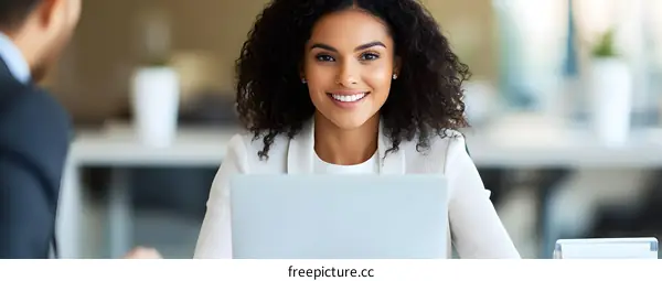 Smiling Businesswoman Working on Laptop in Modern Office
