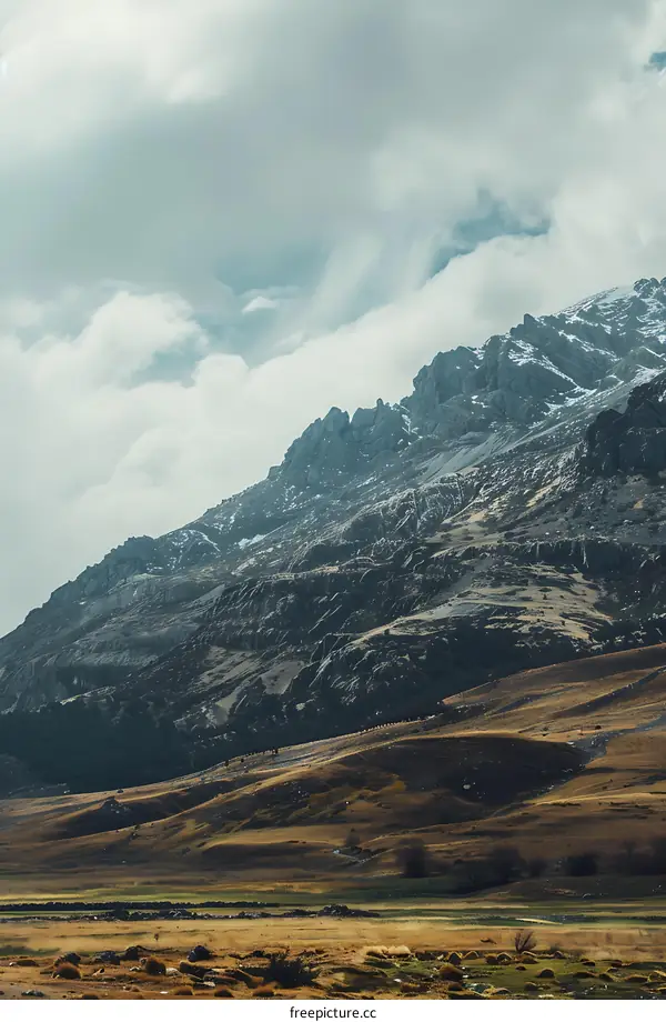 Mountain Landscape with Cloudy Sky and Dry Grassland