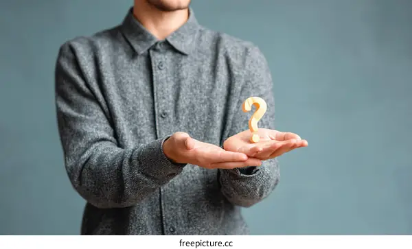 Man holding question mark symbol in hands thinking about solution