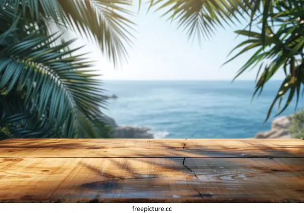 An empty wooden table with palm trees and the ocean in the background