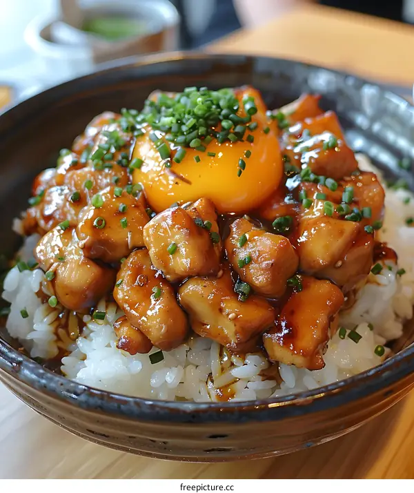 Close Up of Teriyaki Chicken with Egg Yolk and Rice in Bowl