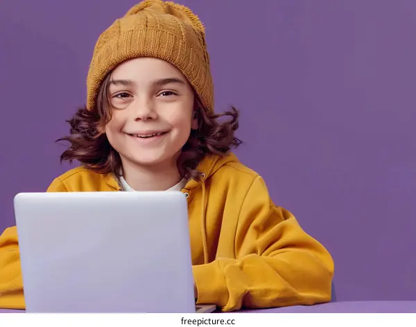 Smiling schoolboy using laptop