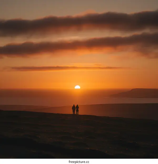 Couple Silhouettes Watching Sunset Over the Ocean