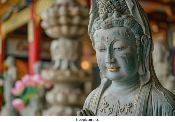 A close up of a statue of a Buddhist goddess with a serene expression on her face