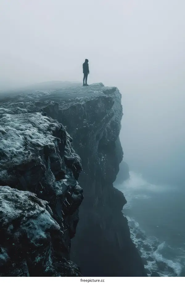 Man standing on a cliff overlooking the ocean