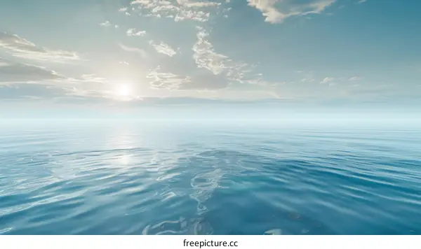 Calm blue ocean with white clouds and bright sun