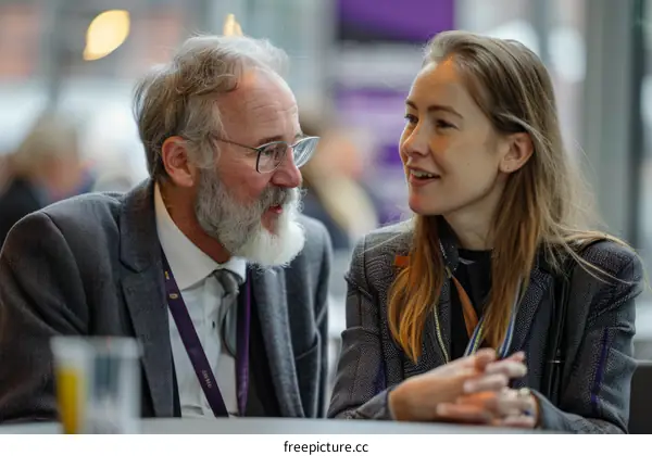 A man and a woman are talking to each other at a conference.