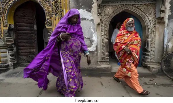 Two People Walking in Front of a Building with Intricate Carvings