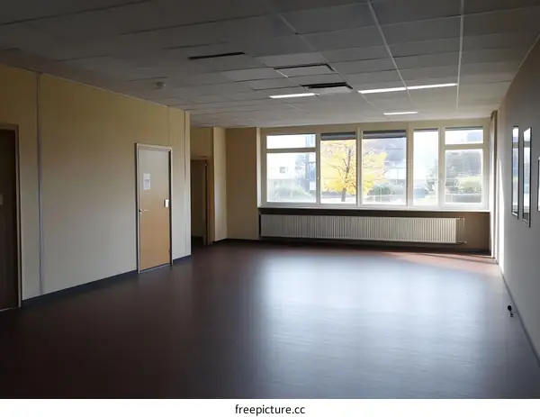 Empty Room with Large Windows and Wooden Floor