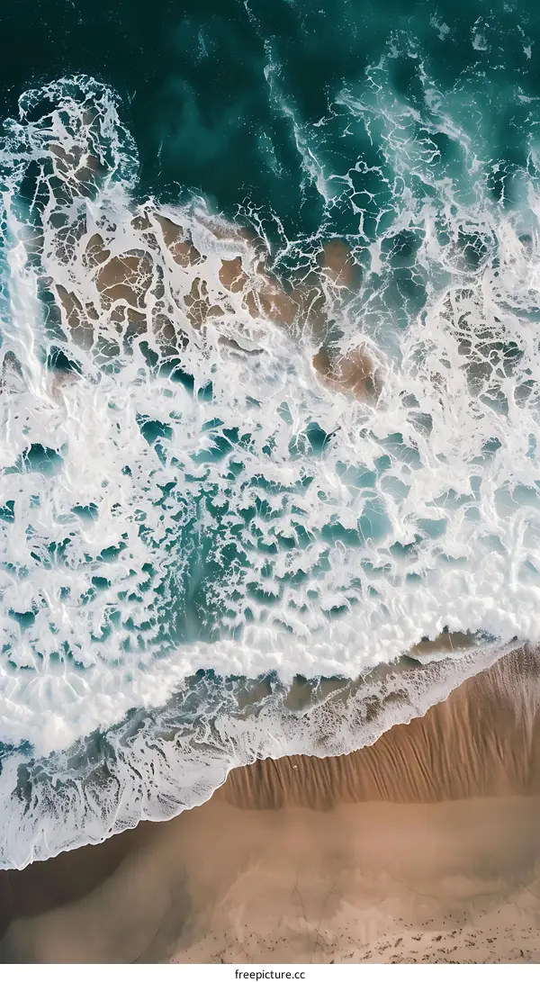 Aerial View of Ocean Waves Crashing on Sandy Beach