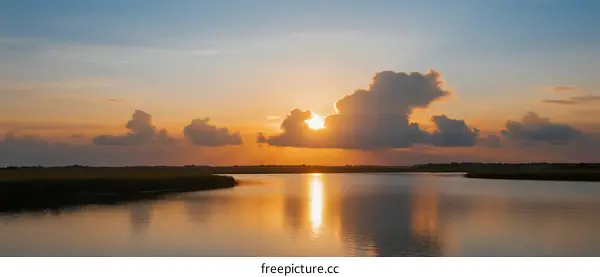 Beautiful Sunset Over a Calm River with Fluffy Clouds