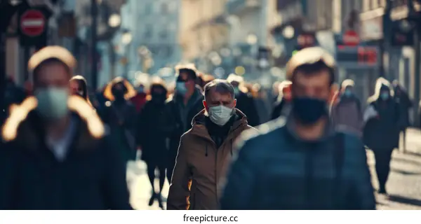 Crowded city street with people wearing medical face masks during COVID-19 pandemic