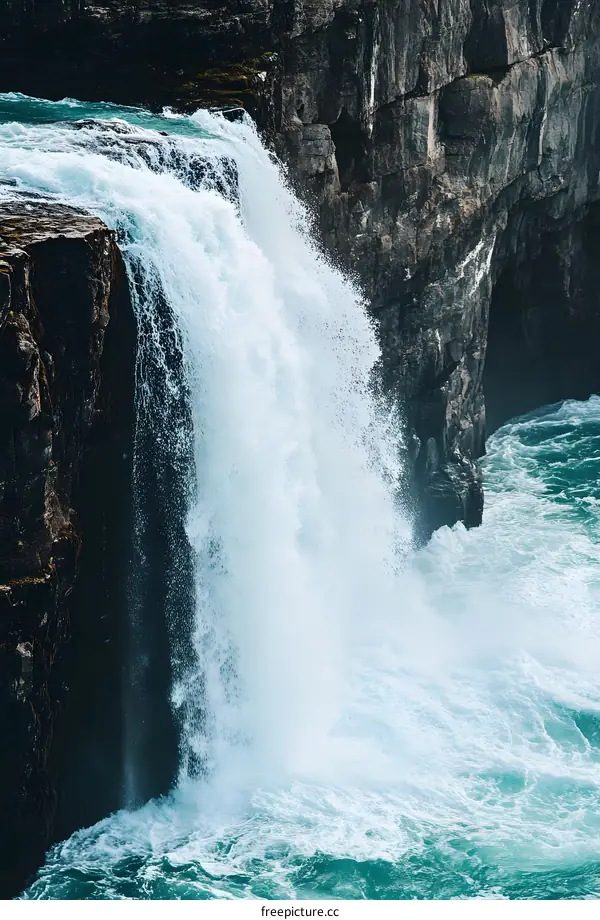 Waterfall Flowing Into Ocean With Cliff In Background