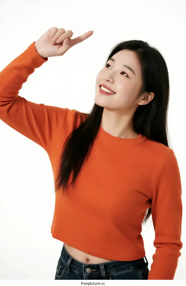 Young woman in orange top pointing with hand
