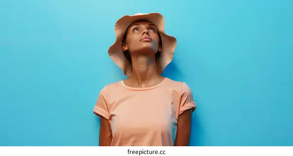 Young woman wearing a hat looking up
