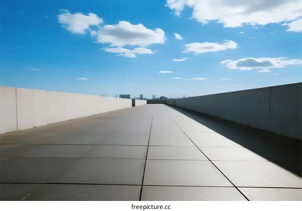 A Clear Blue Sky with White Clouds Over an Empty Rooftop
