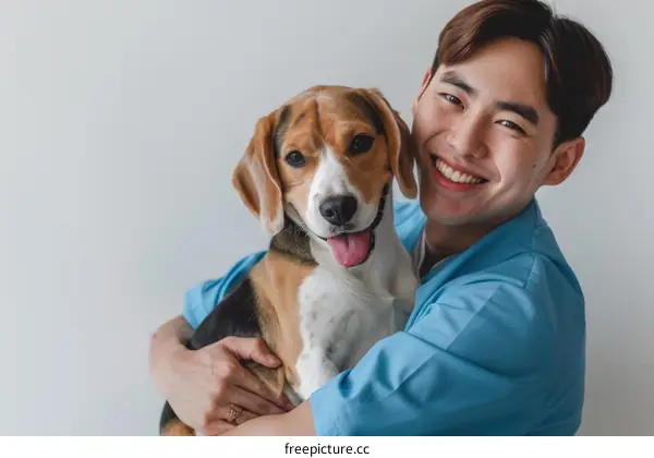 Asian male veterinarian hugging a beagle dog