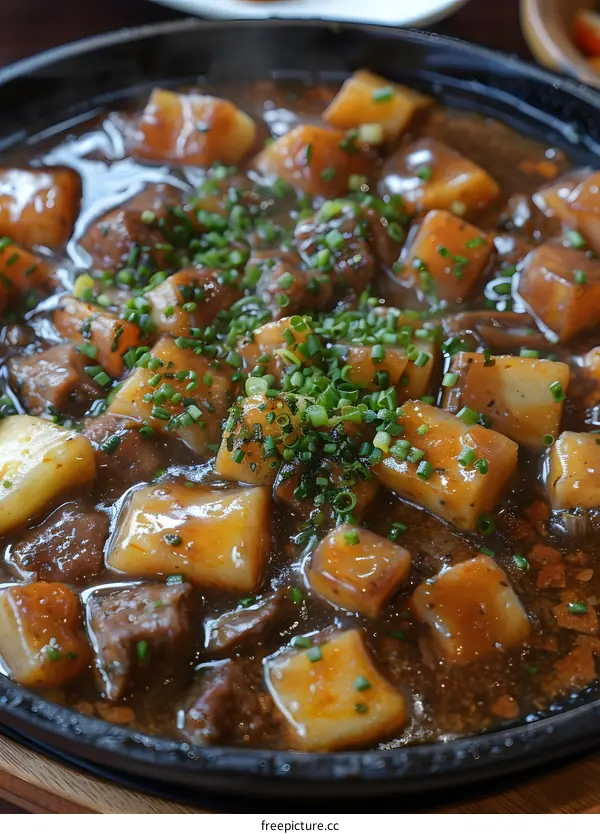 A plate of diced beef and potatoes in brown sauce